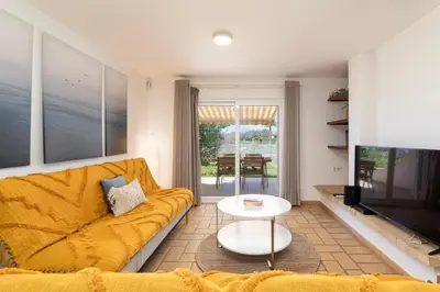 a living room with a yellow couch and a tv at The Albufeira Concierge - Villa Pool & Tennis in Albufeira