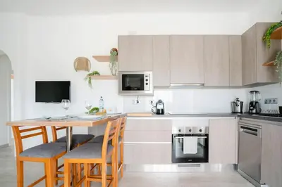 a kitchen with a wooden table with chairs and a counter at Casa Azinheira 1ºa- Albufeira in Albufeira