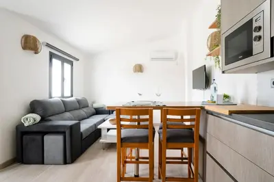 a living room with a couch and a table and chairs at Casa Azinheira 1ºa- Albufeira in Albufeira