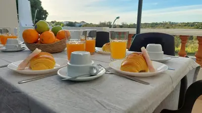a table with plates of food and glasses of orange juice at Casa Azinheira 1ºa- Albufeira in Albufeira