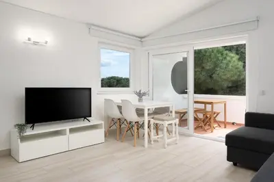 a living room with a tv and a table with chairs at Sunny Albufeira - 5min to the beach by LovelyStay in Albufeira