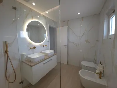 a bathroom with a toilet and a sink and a mirror at Apartamento CPiscina-Albufeira in Albufeira
