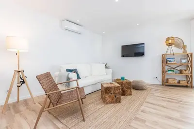 a living room with a white couch and a chair at New 2bedroom Apartment w Terrace & Infinity Pool in Olhos de Água