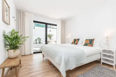 a white bedroom with a large bed and a window at New 2bedroom Apartment w Terrace & Infinity Pool in Olhos de Água
