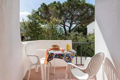 a woman sitting at a table on a balcony at Apartment Maresia in Albufeira