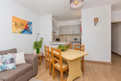 a living room and kitchen with a table and a couch at Apartment Maresia in Albufeira