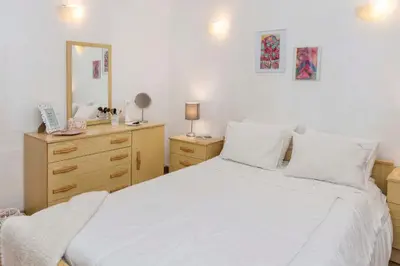 a bedroom with a white bed and a dresser at Apartment Maresia in Albufeira