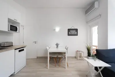 a kitchen and living room with a table and a couch at Bright Albufeira - 5min to the beach by LovelyStay in Albufeira