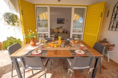 a dining room with a wooden table and chairs at Villa PACA Algarve Vilamoura 8 personnes in Quarteira