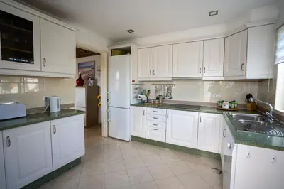 a kitchen with white cabinets and a sink at Villa PACA Algarve Vilamoura 8 personnes in Quarteira