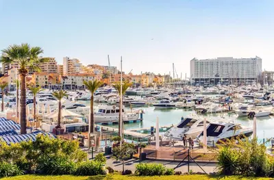 a marina with boats in a harbor with palm trees at Villa PACA Algarve Vilamoura 8 personnes in Quarteira