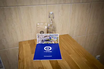 a book on a table next to a bottle of water at Pink House in Faro