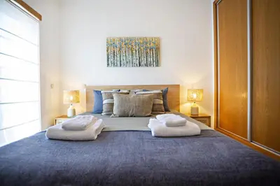 a bedroom with a large bed with two towels on it at Pink House in Faro
