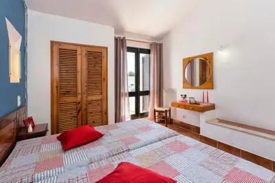 a bedroom with a large bed and a bathroom at Villa Jacaranda in Albufeira