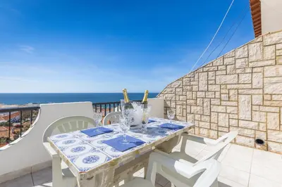 a table and chairs on a balcony with the ocean at Oceanview Apartment A by Sequeira in Albufeira