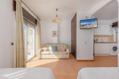 a living room with a couch and a kitchen at Oceanview Apartment A by Sequeira in Albufeira