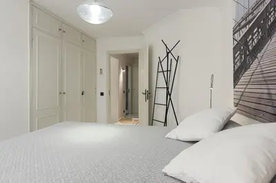 a white bedroom with a large bed with white sheets at Scandic - City Center by HD Properties in Vilamoura