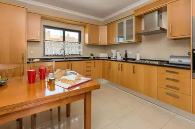 a kitchen with wooden cabinets and a wooden table at Villa Anabela in Albufeira