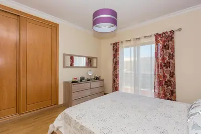 a bedroom with a bed and a dresser and a window at Villa Anabela in Albufeira