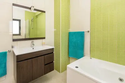 a bathroom with a tub and a sink and a mirror at Villa Anabela in Albufeira
