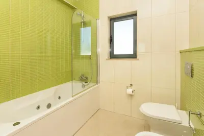 a bathroom with a toilet and a window at Villa Anabela in Albufeira