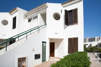 a white house with a green door and stairs at Vila Alba by Albufeira Rental in Albufeira