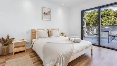 a white bedroom with a bed and a large window at Dream Apartment W/Pool & Balcony by LovelyStay in Albufeira