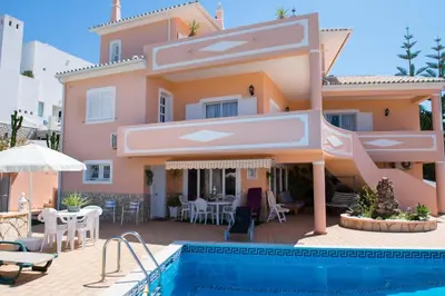 a villa with a swimming pool in front of a house at Villa Malu in Albufeira