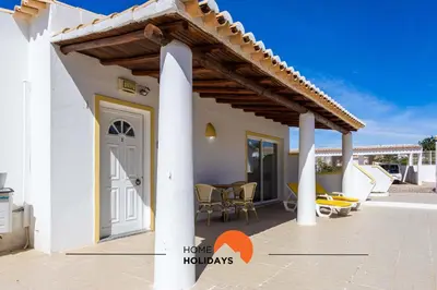 a white house with a wooden pergola at #133 Vila Dias 1 by Home Holidays in Albufeira