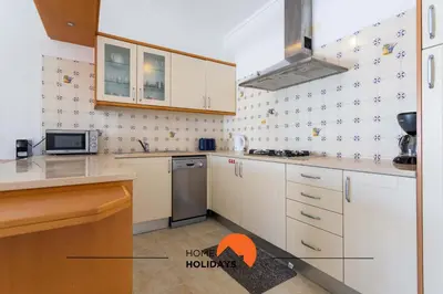 a kitchen with white cabinets and a microwave at #133 Vila Dias 1 by Home Holidays in Albufeira