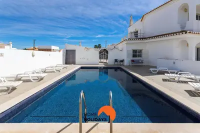 a swimming pool in front of a white house at #133 Vila Dias 1 by Home Holidays in Albufeira