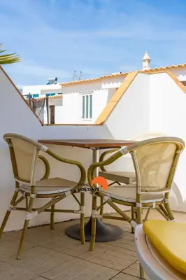 a table and chairs on a patio with a boat at #133 Vila Dias 1 by Home Holidays in Albufeira