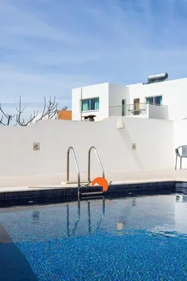 a swimming pool in front of a white building with a house at #134 Vila Dias 2 by Home Holidays in Albufeira