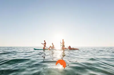 a group of people on a surfboard in the water at #114 T2 Foxy H by Home Holidays in Albufeira