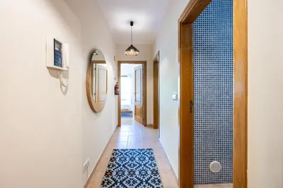 a hallway with a walk in shower and a tile floor at Jacaranda in Albufeira