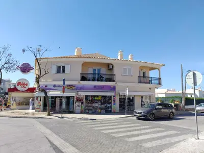 a building with a car parked in front of a street at Candyland Apartment in Albufeira