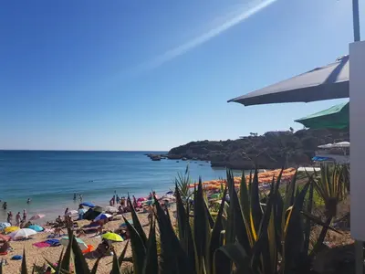 people on a beach with umbrellas and the ocean at Candyland Apartment in Albufeira