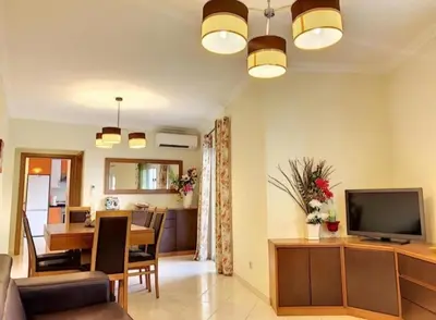 a living room with a television and a dining room at Candyland Apartment in Albufeira