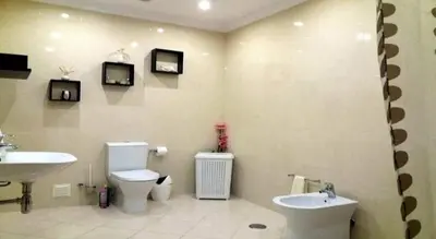 a bathroom with a toilet and a sink and two televisions at Candyland Apartment in Albufeira