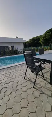 a table and chairs sitting next to a swimming pool at Valverde 2 Villa, Vilamoura, Algarve, only 5 minutes from Marina, Golf and Beach in Vilamoura