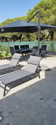 a group of lounge chairs and a table with an umbrella at Valverde 2 Villa, Vilamoura, Algarve, only 5 minutes from Marina, Golf and Beach in Vilamoura
