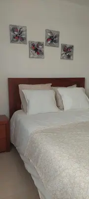 a bed with four butterflies on the wall at Appart Oura Strip in Albufeira