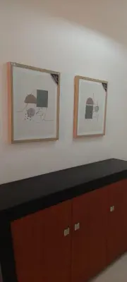 two framed pictures on a wall above a cabinet at Appart Oura Strip in Albufeira