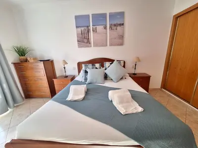a large bed with two pillows on it in a bedroom at Ondasol- acolhedor T2 na cidade velha in Albufeira