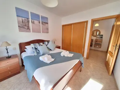 a bedroom with a bed with towels on it at Ondasol- acolhedor T2 na cidade velha in Albufeira