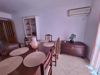 a dining room with a wooden table and chairs at Ondasol- acolhedor T2 na cidade velha in Albufeira