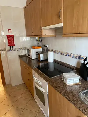 a kitchen with a counter top with a microwave at Ondasol- acolhedor T2 na cidade velha in Albufeira