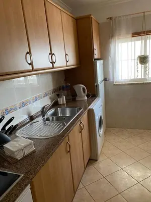 a kitchen with a sink and a washing machine at Ondasol- acolhedor T2 na cidade velha in Albufeira