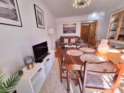 a living room with a table and a dining room at Ondasol- acolhedor T2 na cidade velha in Albufeira