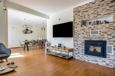 a living room with a fireplace and a tv on a brick wall at Villa Casa Vilas Boas in Albufeira